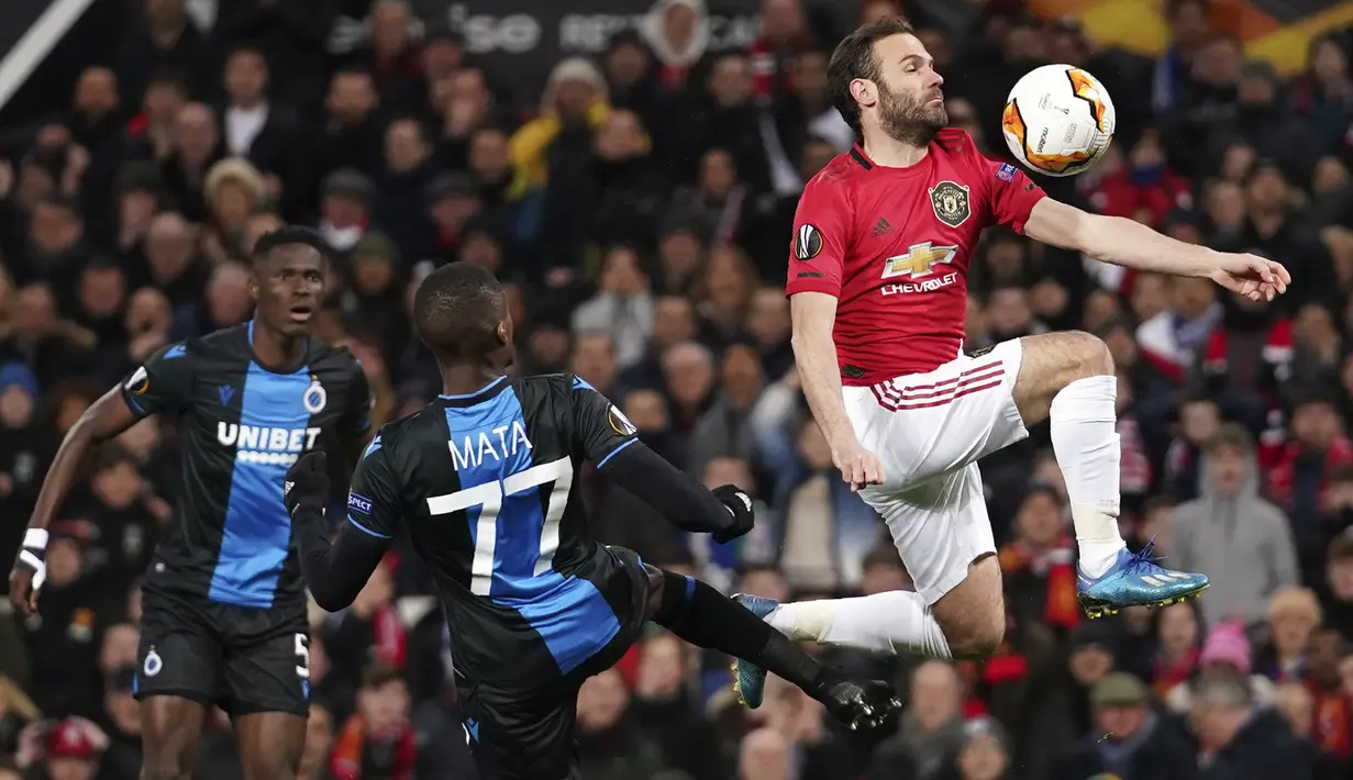 Gelandang Manchester United, Juan Mata (kanan) berusaha mengontrol bola dari kawalan pemain Club Brugge, Clinton Mata pada pertandingan leg kedua babak 32 besar Liga Europa di Old Trafford, Inggris, Kamis, (27/2/2020). MU menang telak 5-0 atas Club Brugge. (AP Photo/Dave Thompson)