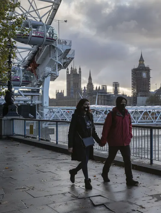 Sejumlah warga yang mengenakan masker berjalan di tepi Sungai Thames di London, Inggris (31/10/2020). Kasus baru COVID-19 di Inggris mencapai 21.915, menambah total kasus coronavirus di negara itu menjadi 1.011.660. (Xinhua/Han Yan)