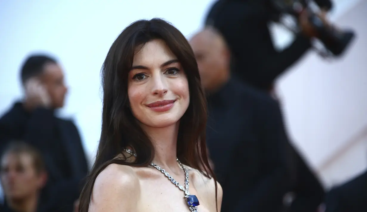 Anne Hathaway berpose untuk fotografer setibanya di pemutaran perdana film 'Armageddon Time' di festival film internasional ke-75, Cannes, Prancis selatan (19/5/2022). Anne Hathaway mengenakan kalung Mediterranean Reverie. (AP Photo/Joel C Ryan)