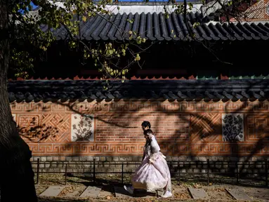 Orang-orang mengenakan Hanbok (pakaian tradisional Korea) saat mereka mengunjungi halaman Istana Gyeongbokgung di Seoul pada tanggal 2 November 2023. (ANTHONY WALLACE/AFP)