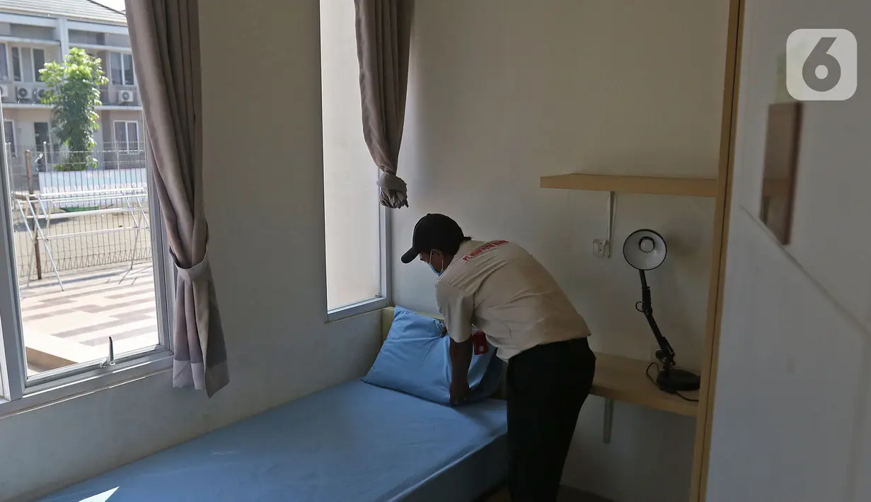 Petugas sedang merapikan kamar di rumah isolasi terpusat Bekasi Berantas  Pendemi (Berani) di Jababeka, Cikarang, Kabupaten Bekasi, Jawa Barat, Rabu (28/7/2021). Rumah isolasi tersebut disediakan untuk buruh pabrik di kawasan kabupaten Bekasi. (Liputan6.com/Herman Zakharia)