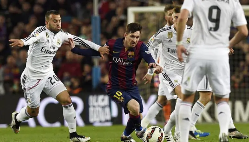Striker Barcelona, Lionel Messi (tengah), beraksi di antara pemain Real Madrid pada El Clasico musim 2014/2015. (AFP/Lluis Gene)