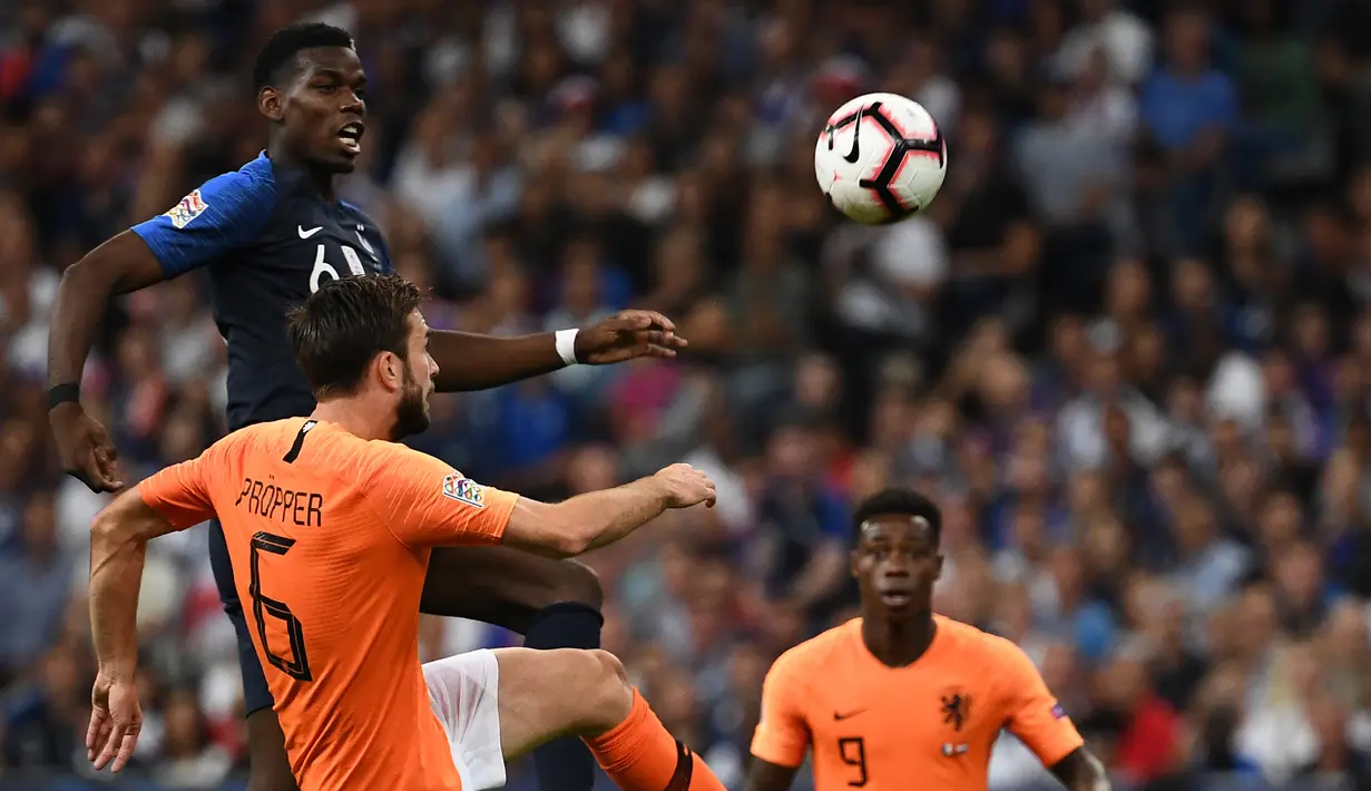 Gelandang Prancis, Paul Pogba, berebut bola dengan gelandang Belanda, Davy Propper, pada laga UEFA Nations League di Stade de France, Paris, Minggu (9/9/2018). Prancis menang 2-1 atas Belanda. (AFP/Anne-Christine Poujoulat)