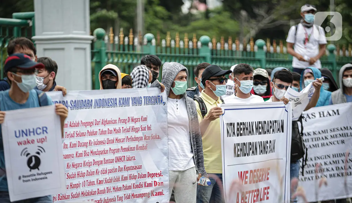 Sejumlah pengungsi Afghanistan membawa spanduk saat berunjuk rasa di kawasan Monas, Jakarta, Rabu (19/1/2022). Mereka menuntut kejelasan untuk berangkat ke negara ketiga setelah lama tinggal di pengungsian. (Liputan6.com/Faizal Fanani)