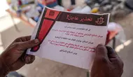 Warga Palestina membaca salah satu selebaran yang dijatuhkan oleh militer Israel di Deir el-Balah di Jalur Gaza Tengah pada tanggal 16 April 2024. (AFP)