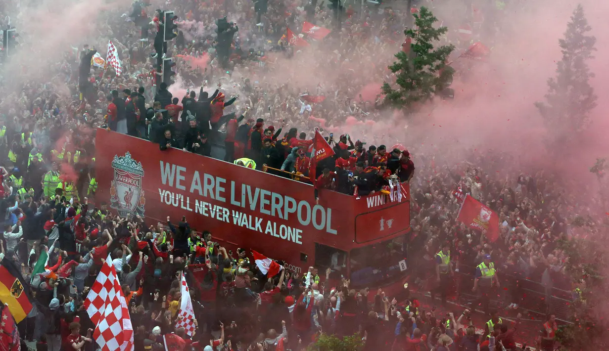 Ribuan fans Liverpool memadati jalan-jalan kota untuk menyambut tim kebanggaan mereka yang melakukan parade di atas bus terbuka pada Minggu (29/05/2022) waktu setempat. Musim ini, The Reds berhasil meraih dua trofi yaitu Piala FA dan Piala Liga Inggris. (AFP/Nigel Roddis)