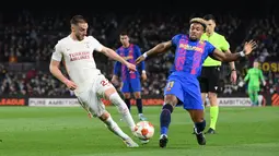 Gelandang Galatasaray, Berkan Kutlu (kiri) berebut bola dengan penyerang Barcelona, Adama Traore selama pertandingan leg pertama babak 16 besar Liga Europa di stadion Camp Nou di Barcelona (11/3/2022). Barcelona bermain imbang atas Galatasaray 0-0. (AFP/Lluis Gene)
