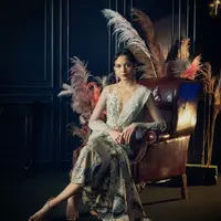 Putri Marino tampil anggun mengenakan kebaya modern brokat putih dipadukan kain batik sebagai bawahan yang juga dari Saptodjojokartiko. Melengkapi penampilan dengan anting-anting dari Tulola. [@netflixid]