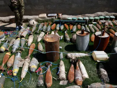 Sejumlah amunisi, mortir dan bahan peledak lainnya diperlihatkan di wilayah barat Mosul, Kamis (6/4). Senjata-senjata tersebut berhasil disita saat melakukan penyisiran lokasi yang menjadi persembunyian militan ISIS di Mosul. (AFP Photo / Ahmad Gharabli)