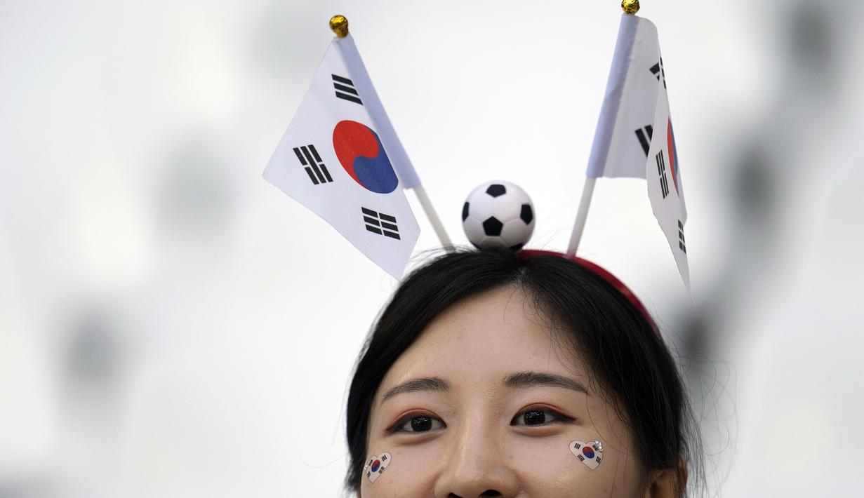 Bukan hanya cantik, mereka juga tampil unik dengan menaruh bendera dan bola kecil dikepala agar menjadi pusat perhatian. (AP Photo/Lee Jin-man)