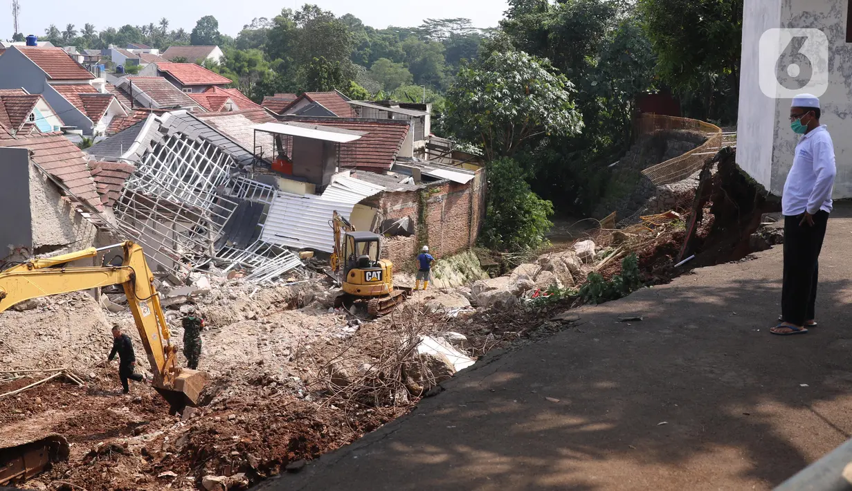 Warga menyaksikan rumah yang hancur tertimpa tanah longsor di Perumahan Nerada Estate Ciputat, Tangerang Selatan, Sabtu (12/6/2021). Tidak ada korban jiwa dalam peristiwa longsor yang menimpa sejumlah rumah akibat hujan deras yang terus menerus di kawasan tersebut. (Liputan6.com/Angga Yuniar)