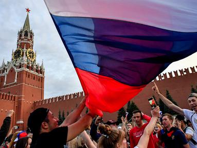 Suporter Rusia berpesta merayakan keberhasilan negaranya mengalahkan Spanyol pada laga 16 besar Piala Dunia di Moskow, Minggu (1/7/2018). Rusia untuk pertama kalinya lolos ke babak perempatfinal. (AFP/Yuri Kadobnov)