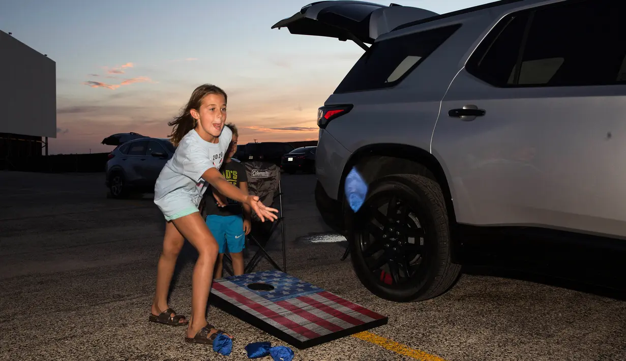 Alyssa Walter (9) bermain saat keluarganya menungggu pemutaran film "Encore Drive-In Nights Presents Blake Shelton," di Stars & Stripes Drive-In Theatre, Texas pada 25 Juli 2020. Konser ini ditayangkan di bioskop drive-in seluruh Amerika Utara. (Mikala Compton/Herald-Zeitung via AP)