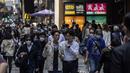 Dua pria mengobrol saat mereka berjalan melalui kawasan pusat bisnis di Hong Kong (1/3/2023). Pemerintah Hong Kong mengumumkan pelonggaran aturan Covid-19 dengan mencabut mandat penggunaan masker pada 1 Maret. Kini, warga Hong Kong bebas seperti sebelum pandemi. (AFP/Isaac Lawrence)