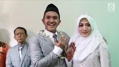 Komedian Caisar Aditya Putra dan Intan Sri Mardiani menunjukkan cincin usai ijab kabul pernikahan di kawasan Cimahpar, Bogor, Jawa Barat, Sabtu (30/6). Caisar resmi menikahi Intan usai bercerai dari Indadari. (Liputan6.com/Herman Zakharia)