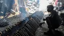 Pekerja membakar lemang yang sudah dibungkus daun pisang dan dimasukkan ke dalam bambu di industri pembuatan lemang kawasan Senen, Jakarta, Selasa (27/4/2021). (Liputan6.com/Johan Tallo)