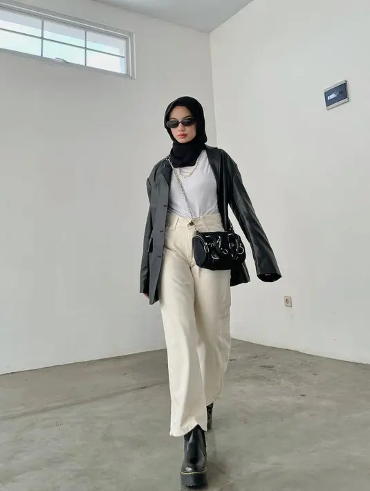 Perpaduan t-shirt dengan leather blazer dan high waist jeans warna putih ini memberikan kesan yang edgy pada look-mu (Instagram/adiva.selsa).