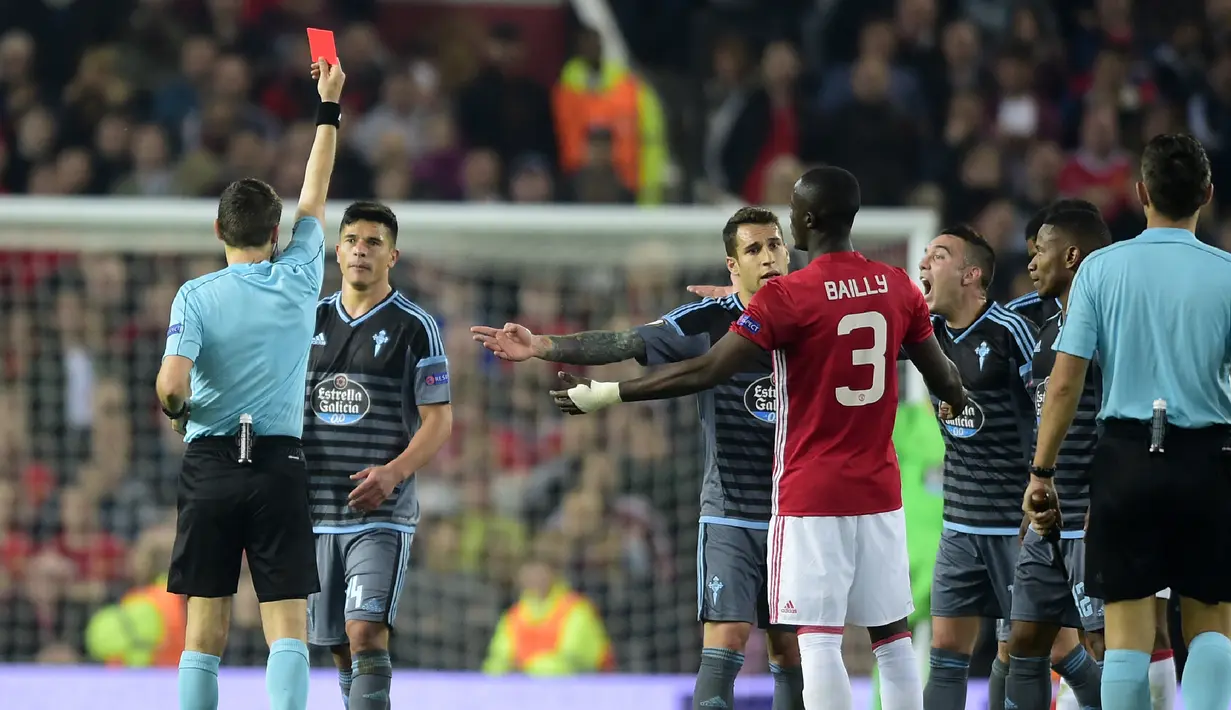 Wasit Ovidiu Hategan memberi kartu merah kepada bek Celta Vigo Facundo Roncaglia dan bek MU, Eric Bailly pada leg kedua Liga Europa di stadion Old Trafford, Inggris,(11/5). Di leg kedua ini MU bermain imbang 1-1 dengan Celta Vigo. (AFP Photo/Miguel Riopa)