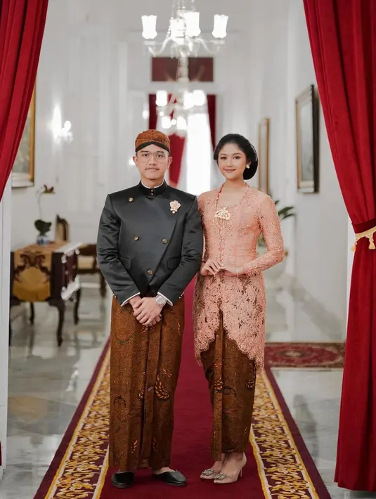 Pesona Kaesang dan Erina tampil dalam balutan busana adat Jawa. Erina tampil anggun penuh pesona dengan kebaya kutubaru berwarna merah muda, dipadu kain batik sebagai bawahan yang serasi dengan padu padan beskap hitam dan kain batik, serta blangkon yang dipilih Kaesang. [Foto: Instagram/kaesangp]