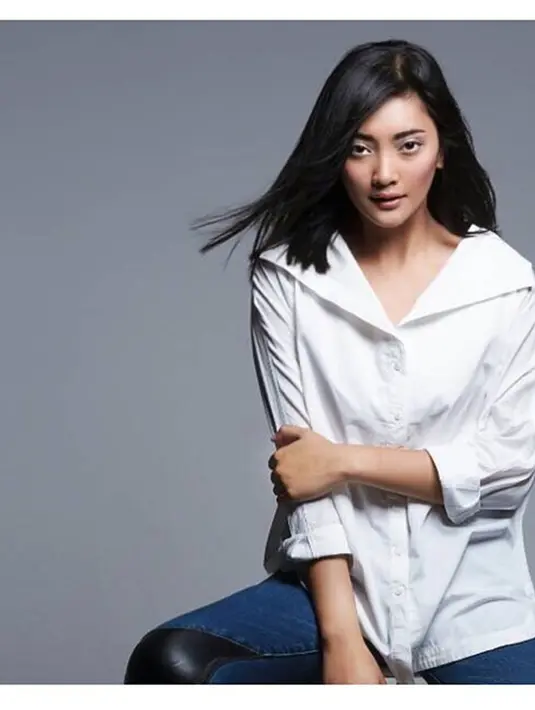 Kemeja berwarna putih memang tak ada matinya untuk dipadupadankan dengan celana jeans. Dalam pemotretan ini, ia juga memilih mengurai rambutnya serta menggunakan makeup sederhana. (Liputan6.com/IG/@dindacresheilla)