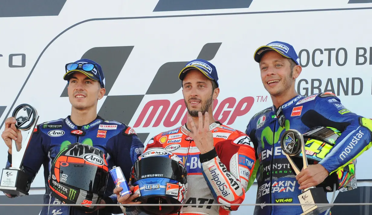 Pembalap Ducati Andrea Dovizioso, berpose dengan dua pembalap Yamaha Maverick Vinales dan Valentino Rossi, setelah berhasil finish di urutan terdepan pada GP Inggris di Sirkuit Silverstone, Minggu (27/8). (AP Photo/Rui Vieira)