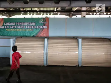 Seorang anak bermain dekat kios penampungan pedagang kaki lima (PKL) yang kosong di Blok F Tanah Abang, Jakarta, Kamis (31/1). Hingga kini tempat untuk PKL yang tidak memperoleh lapak di skybridge Tanah Abang itu tak diminati. (Liputan6.com/Faizal Fanani)
