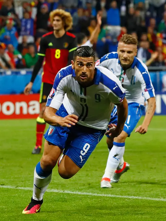Penyerang Italia, Graziano Pelle (depan) melakukan selebrasi usai mencetak gol kegawang Belgia pada pertandingan grup E Piala Eropa di Stade de Lyon, Prancis, (14/6). Italia menang atas Belgia dengan skor 2-0. (REUTERS/Jason Cairnduff)