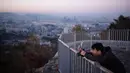 Seorang pejalan kaki mengabadikan kota Seoul selama matahari terbit di Korea Selatan (31/10). Kota Seoul juga merupakan pusat bisnis, keuangan, perusahaan multinasional, dan organisasi global. (AFP Photo/Ed Jones)