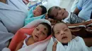 Perawat menggendong bayi yang baru lahir di bangsal anak di rumah sakit Guwahati 10 Juli 2014. Sebuah penelitian baru dari PBB memprediksi bahwa India akan melampaui China sebagai negara dengan penduduk terbanyak pada tahun 2022.(AFP Photo/Biju BORO)