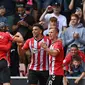 Para pemain Southampton melakukan selebrasi usai tendangan Che Adams (kedua dari kanan) dibelokkan pemain Manchester United Fred sehingga menghasilkan gol bunuh diri pada pertandingan Liga Inggris di Stadion St Mary, Southampton, Inggris, 22 Agustus 2021. Pertandingan berakhir 1-1. (Glyn KIRK/AFP)