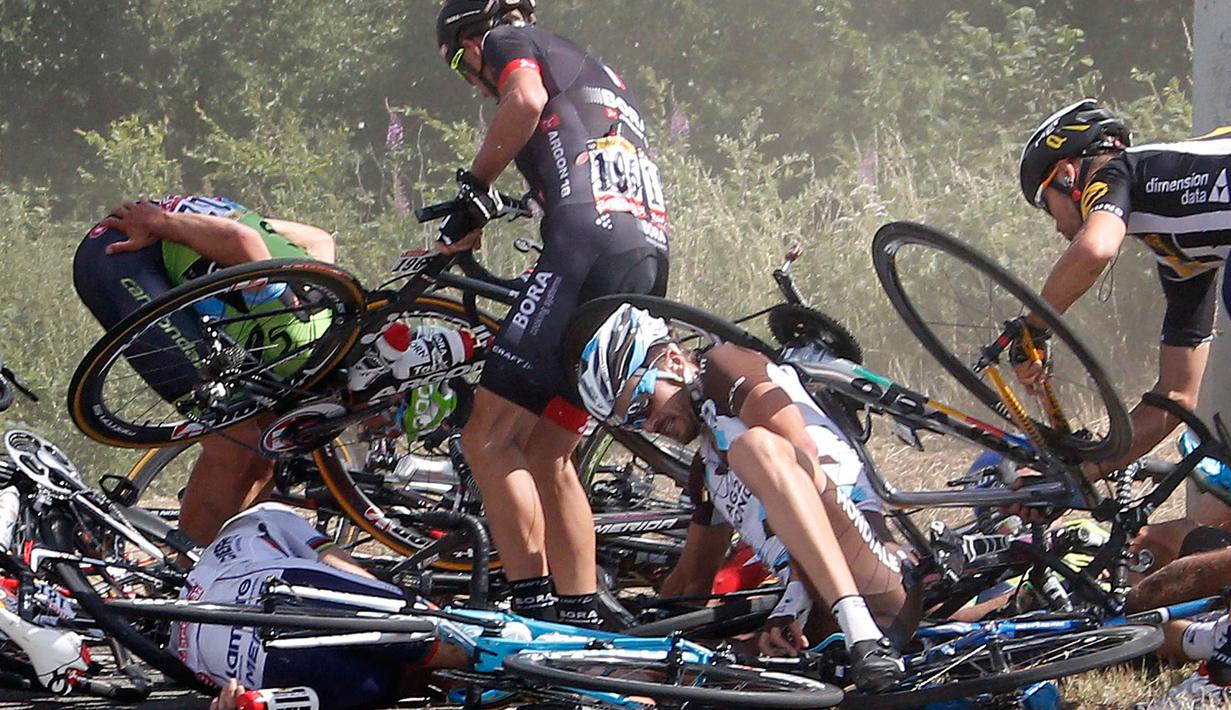 Sejumlah pebalap berusaha mengangkat sepedanya usai terjatuh di jarak 159,5 km (99 mil) dalam babak ketiga Tour de France dari Anvers ke Huy di Belgia, Senin (6/7/2015). (REUTERS/Eric Gaillard)