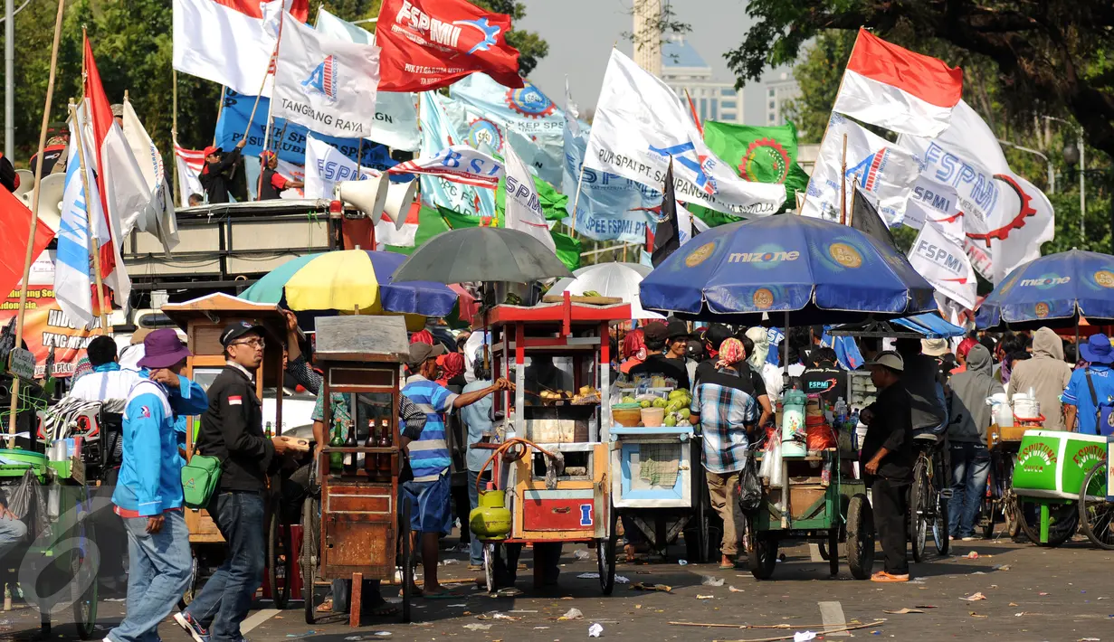 Puluhan pedagang berkumpul menutup ruas jalan Medan Merdeka Selatan saat ribuan buruh dari berbagai elemen organisasi melakukan aksi di depan Istana Negara, Jakarta, Selasa (1/9/2015). (Liputan6.com/Helmi Fithriansyah)