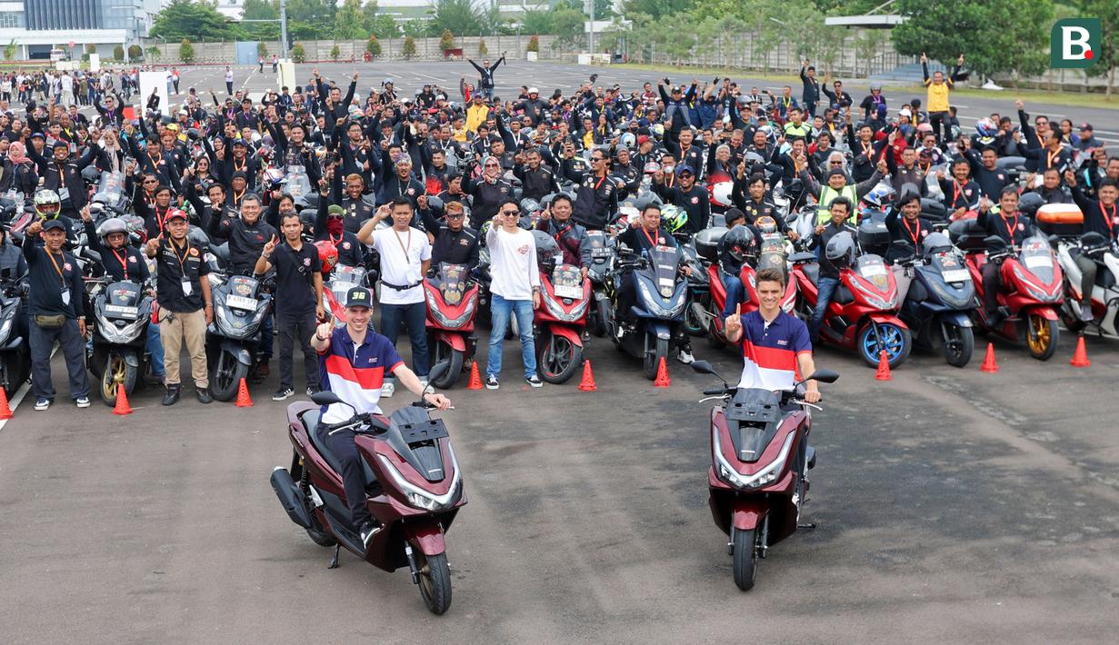 Dua pebalap MotoGP Honda Racing Corporation (HRC) yakni Joan Mir (kiri) dan Luca Marini berfoto besama dengan komunitas dalam acara launching motor baru untuk MotoGP 2025 di pabrik PT Astra Honda Motor (AHM) di Cikarang, Jawa Barat pada Sabtu (1/2/2025). (Bola.com/M. Iqbal Ichsan)