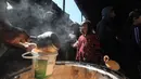 Anak-anak pengungsi Palestina menerima makanan dari dapur amal di kamp pengungsi Nuseirat, Jalur Gaza Tengah pada 13 April 2026. Krisis pangan di Jalur Gaza memasuki fase yang kian mengkhawatirkan. (Eyad Baba/AFP)