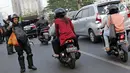 Personel Brimob mengatur arus lalu lintas yang tersendat akibat sejumlah pengendara dan warga berhenti menyaksikan aksi unjuk rasa yang dilakukan mahasiswa dari berbagai perguruan tinggi di sekitar Jembatan Layang Gerbang Pemuda, Jakarta, Selasa (1/10/2019). (Liputan6.com/Helmi Fithriansyah)