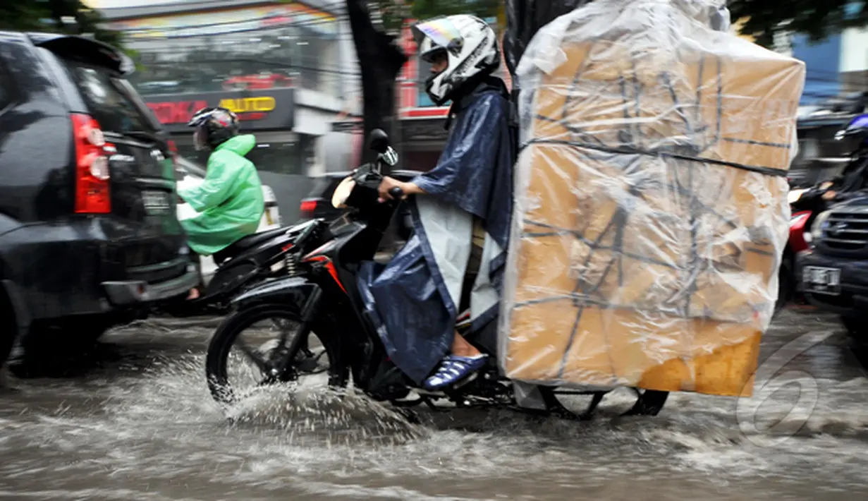 Sejumlah kendaraan melintasi genangan air di Jalan Iskandar, Jakarta, Kamis (22/1/2015). (Liputan6.com/Miftahul Hayat)