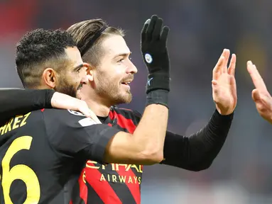 Pemain Manchester City Riyad Mahrez (kiri) merayakan dengan Jack Grealish setelah mencetak gol ke gawang RB Leipzig pada pertandingan sepak bola leg pertama babak 16 Liga Champions di Leipzig, Jerman, 22 Februari 2023. Pertandingan berakhir imbang 1-1. (AP Photo/Andreas Gora)