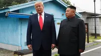 Presiden Amerika Serikat, Donald Trump bertemu dengan Pemimpin Korea Utara, Kim Jong-un di zona demiliterisasi Korea (DMZ), Desa Panmunjom pada Minggu (30/6/2019).  Ini adalah kali pertama seorang presiden AS menginjakkan kaki di negara tersebut. (AP Photo/Susan Walsh)