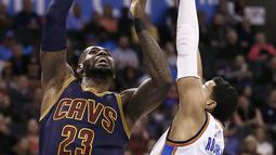 Pebasket Cleveland Cavaliers, LeBron James, dihadang pebasket Oklahoma City Thunder, Andre Roberson. Pada laga ini LeBron hanya mampu mencetak 18 poin. (EPA/Larry W.Smith)