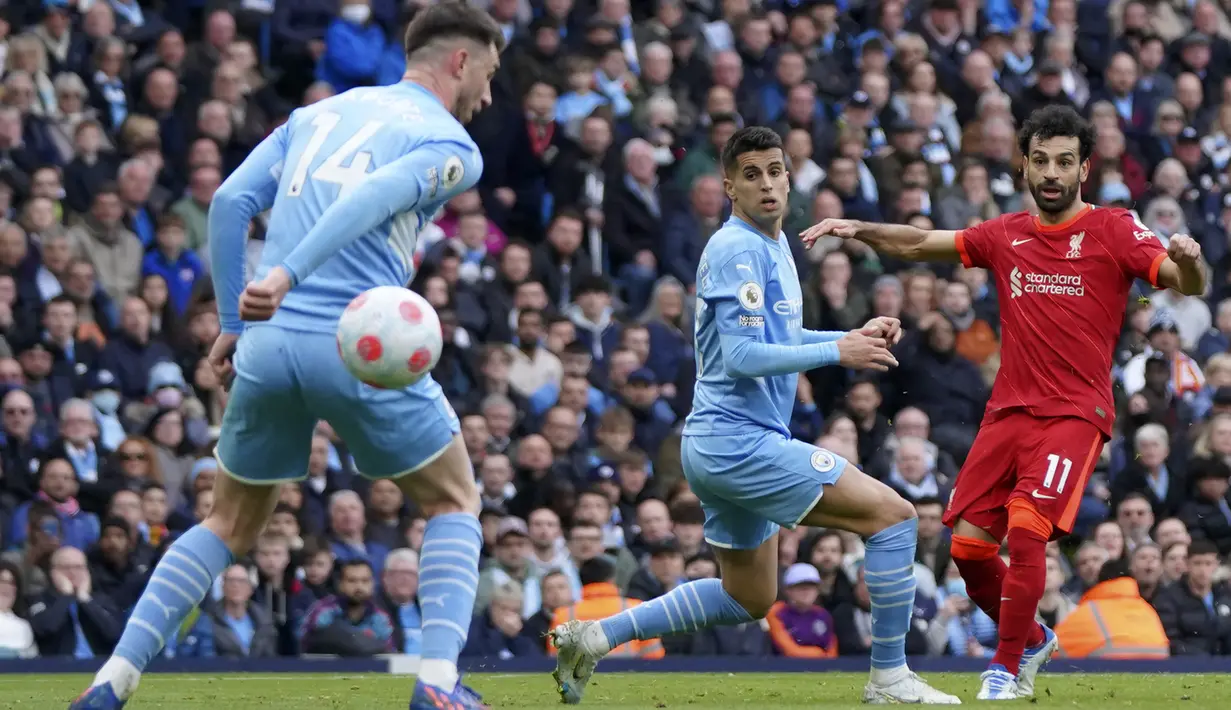 Pemain Liverpool Mohamed Salah (kanan) menendang bola saat melawan Manchester City pada pertandingan sepak bola Liga Inggris di Etihad Stadium, Manchester, Inggris, 10 April 2022. Laga berakhir imbang 2-2. (AP Photo/Jon Super)