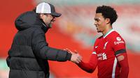 Jurgen Kloop memberikan selamat kepada Trent Alexander-Arnold usai berhasil membawa Liverpool menang atas Aston Villa di menit akhir pertandingan. (Foto: AFP/Pool/Clive Brunskill)