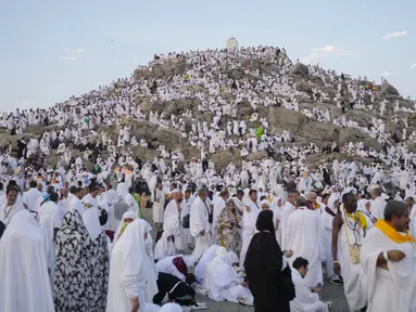 Umat muslim berkumpul di puncak bukit berbatu yang dikenal sebagai Gunung Rahmat di Dataran Arafah saat menunaikan ibadah haji dekat Kota Suci Makkah, Arab Saudi, Sabtu (15/6/2024). (AP Photo/Rafiq Maqbool)