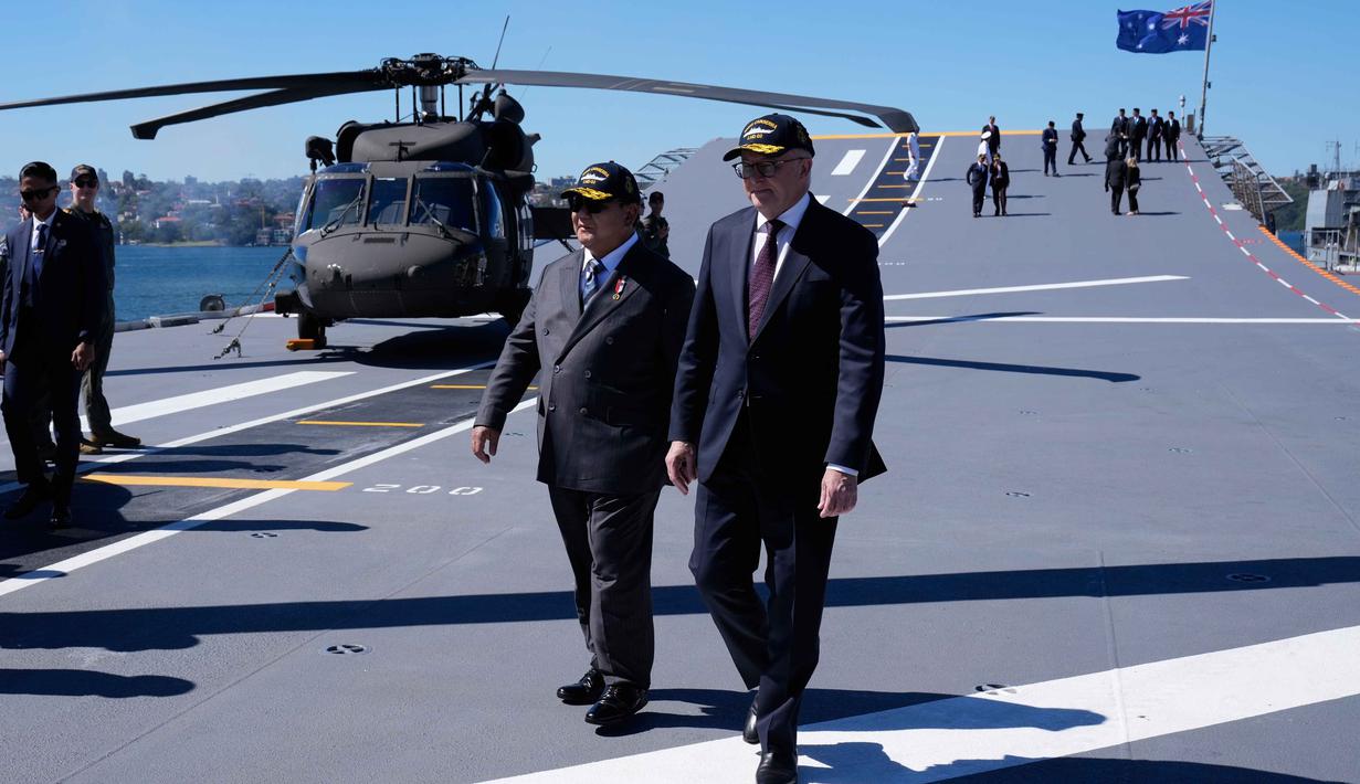 Presiden Indonesia Prabowo Subianto (kiri) bersama Perdana Menteri Australia Anthony Albanese berjalan di dek kapal HMAS Canberra di pangkalan armada Kuttabul di Sydney, Australia, Rabu 12 November 2025. Presiden Prabowo Subianto meninjau langsung Kapal HMAS Canberra di Garden Island Naval Base, Australia. (AP Photo/Rick Rycroft)