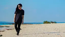 Saat berlibur di pantai, Kikan juga tetap mengenakan busana serba hitam. Ia juga mengenakan kacamata berwarna hitam sebagai pelengkap. (Liputan6.com/IG/@kikankikan)