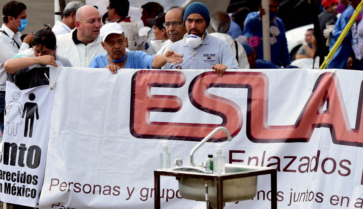 Suasana tempat penggalian yang dipadati oleh kerabat-kerabat korban kuburan massal di Tetelzingo, Morelos, Meksiko (23/5).Saat ditemukan, korban yang di kubur massal tersebut hanya terbungkus plastik.  (ALFREDO ESTRELLA / AFP)