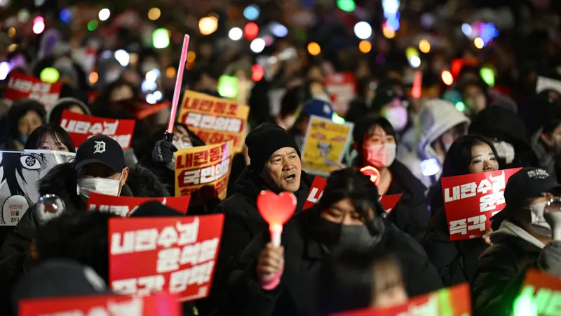 Demonstran di Korea Selatan membawa light stick dalam aksi protes menuntut Presiden Yoon Suk Yeol mundur. (Anthony WALLACE / AFP)
