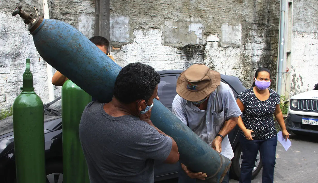 Anggota keluarga pasien COVID-19 yang dirawat di rumah sakit membawa tangki oksigen kosong untuk mengisinya kembali, di Manaus, negara bagian Amazonas, Brasil, 15 Januari 2021. Negara Bagian Amazonas di Brasil kehabisan oksigen karena semakin melonjaknya pasien Covid-19. (AP Photo/Edmar Barros)
