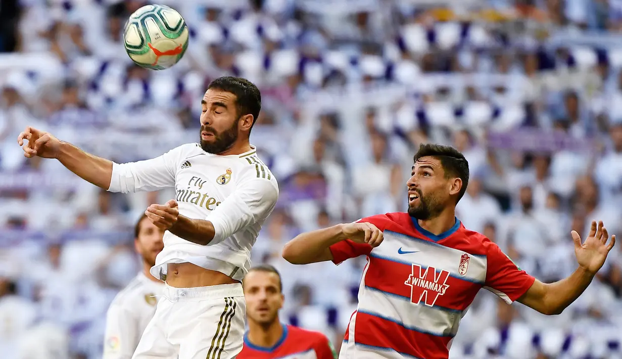 Bek Real Madrid, Dani Carvajal, menyundul bola saat melawan Granada pada laga La Liga Spanyol di Stadion Santiago Bernabeu, Madrid, Sabtu (5/10). Madrid menang 4-2 atas Granada. (AFP/Pierre-Philippe Marcou)