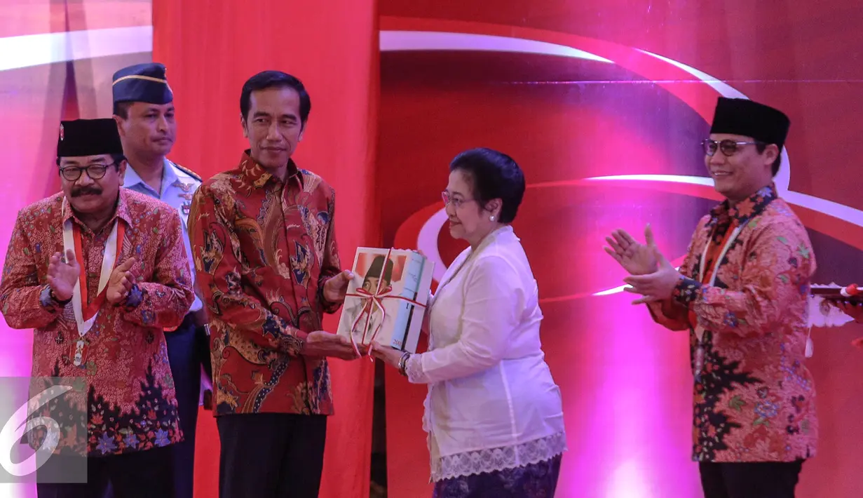 Megawati memberikan buku kepada Presiden Jokowi saat pembukaan Kongres III Persatuan Alumni GMNI, Jakarta, Jumat (8/7/2015). Kongres bertajuk Jalan Trisakti Menuju Tatanan Masyarakat Pancasila dihadiri sekitar 1.000 peserta. (Liputan6.com/Faizal Fanani)