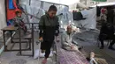 Saat ini, Rateb Mahmoud Qaliq, yang berasal dari desa Badui di Jalur Gaza utara, mengungsi dan tinggal bersama kakeknya di sebuah sekolah UNRWA di Deir al-Balah, Jalur Gaza tengah, yang berfungsi sebagai tempat penampungan. Tampak dalam foto, Rateb Mahmoud Qaliq bersama kakeknya di halaman sekolah UNRWA yang telah menjadi tempat penampungan bagi pengungsi Palestina di Deir al-Balah, di Jalur Gaza tengah, pada 3 Desember 2025. (Bashar Taleb/AFP)